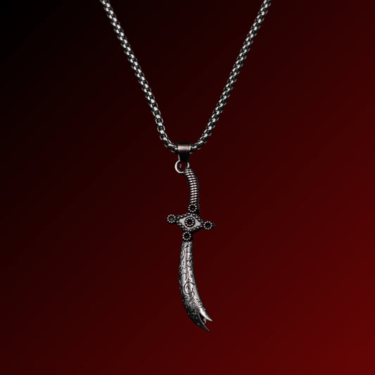 Silver dagger-shaped pendant on a chain against a dark red background